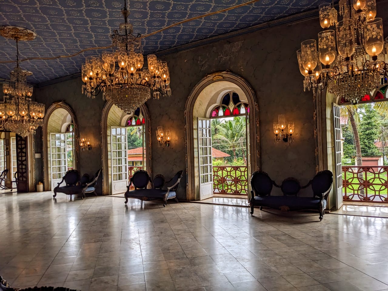 Elegant doors leading to a spacious balcony, framed by luxurious furniture, enhancing the ballroom's charm and sophistication.