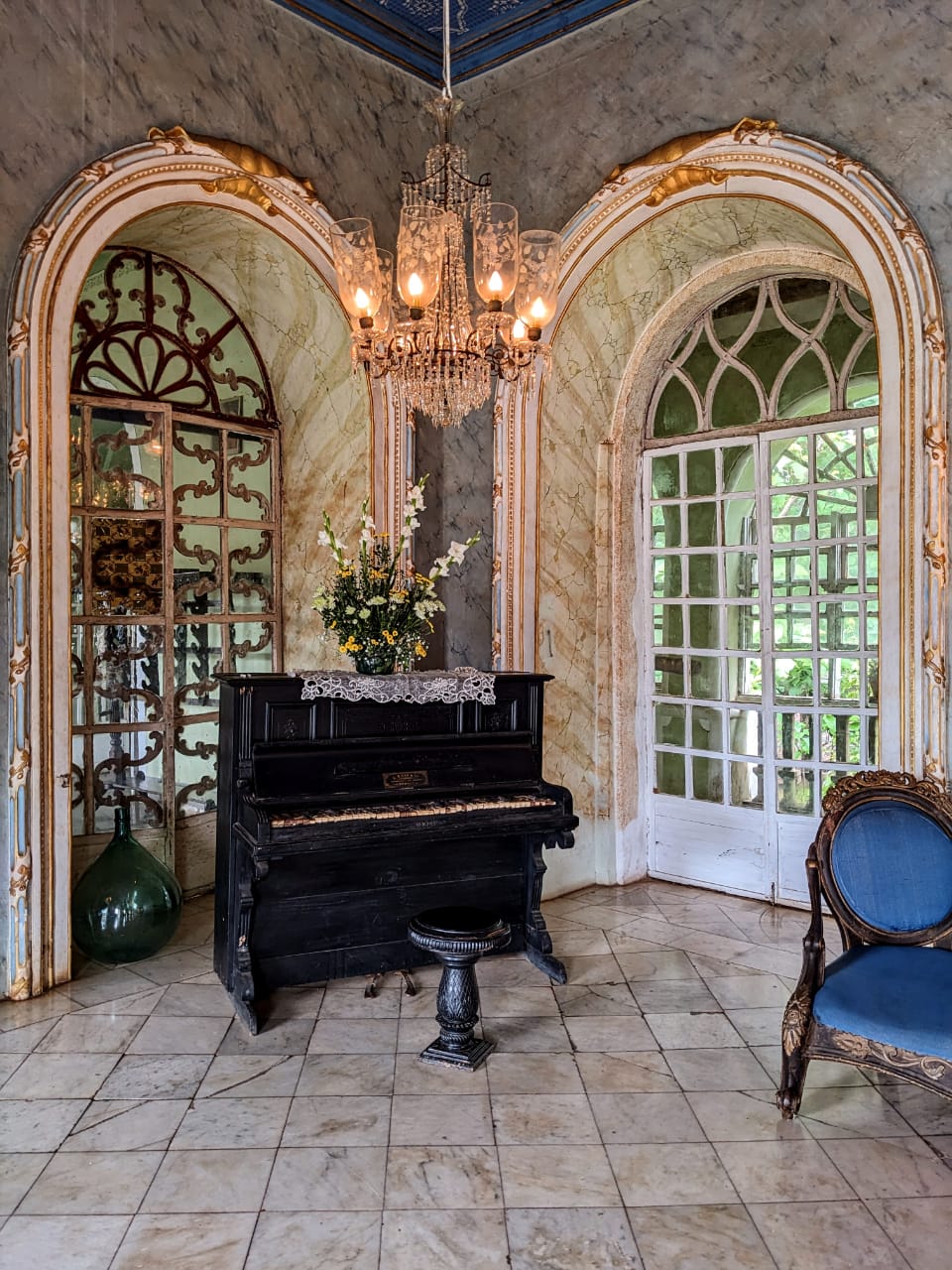 Elegant ballroom at Braganza House showcasing a classic grand piano against a backdrop of refined decor.