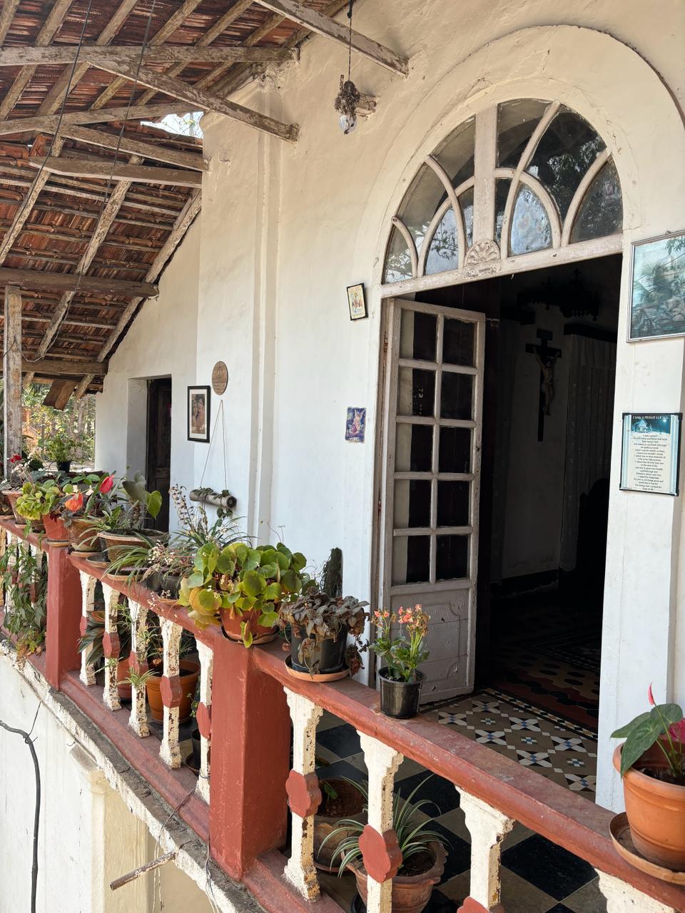 Close-up of the chapel's entrance at Braganza House, highlighting the decorative archway and vibrant flora surrounding the doorway.